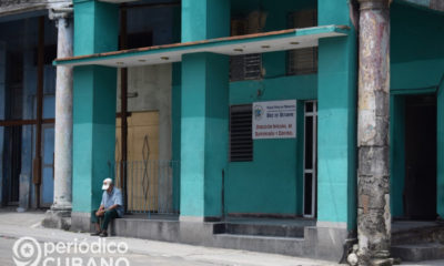 Hombre sentado en frente a una estación de policía en 10 de Octubre, La Habana