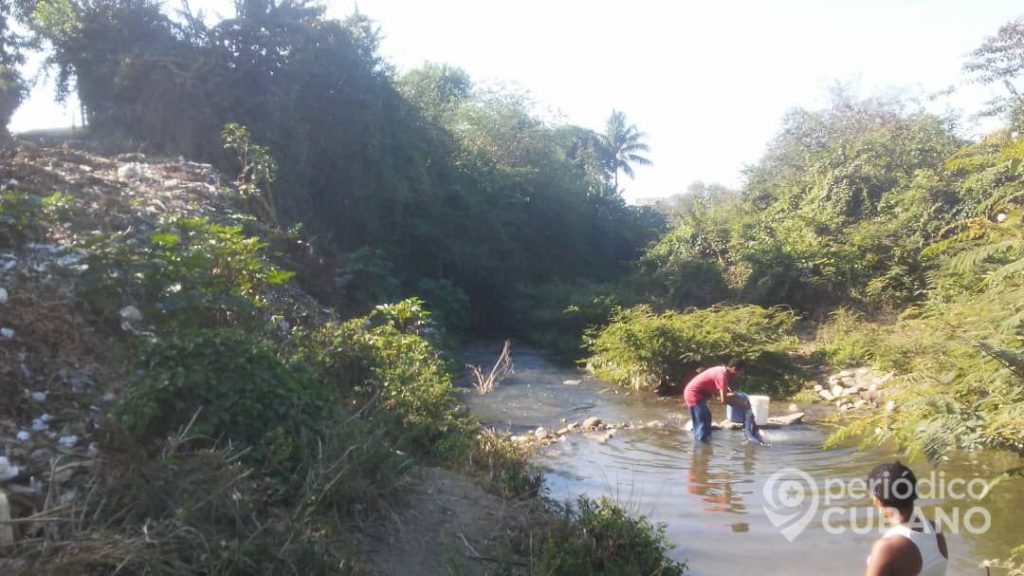 Guantanameros sin servicio de agua potable se abastecen de un río contaminado 