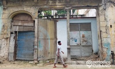 Persona con nasobuco y edificios derrumbe. (Foto Periódico Cubano)