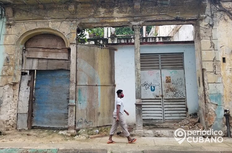 Persona con nasobuco y edificios derrumbe. (Foto Periódico Cubano)
