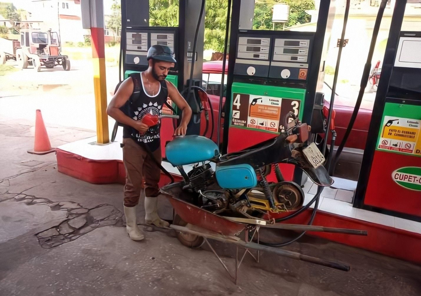 Crisis de combustible en Cuba joven transporta su moto en carretilla para llegar a la gasolinera