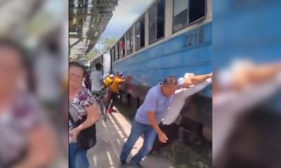 El día a día en la Isla cubanos empujan un tren para que arranque en plena estación