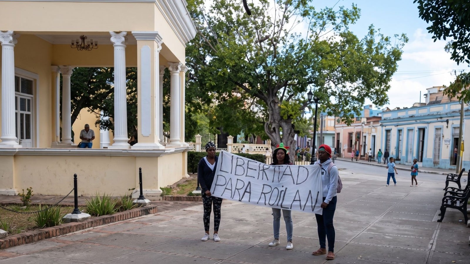 Tres mujeres se manifiestan por la libertad de Roilán Alvarez en el parque de Holguín